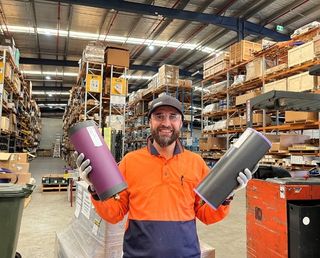 Warehouse supervisor lifting two lightweight conveyor rollers